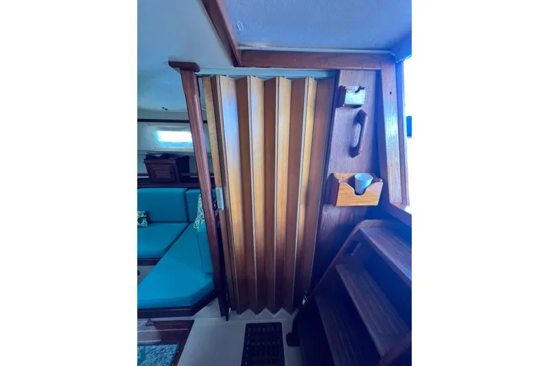Slide: The Image of Interior of 1987 Island Packet SP Cruiser with wooden folding door and teal seating. - 77