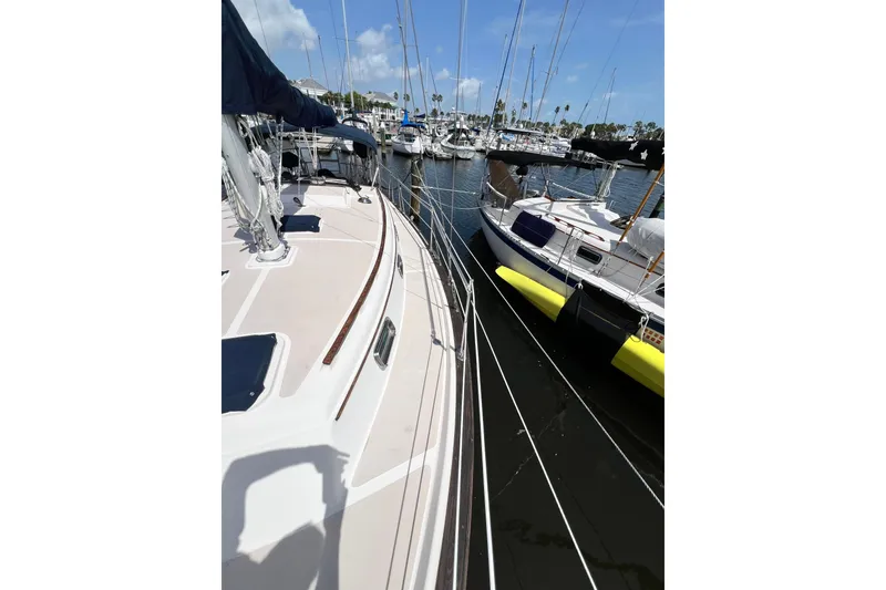 Slide: The Image of 1987 Island Packet SP Cruiser docked at marina, surrounded by other sailboats. - 11