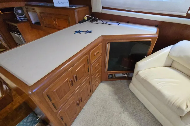 Slide: The Image of Interior of a 1990 Pace 42 yacht with wooden cabinetry and a white armchair. - 25