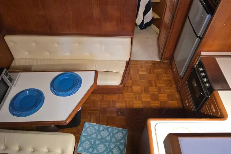Slide: The Image of Cozy 1990 Pace 42 yacht interior with dining area, blue plates, and kitchen appliances. - 40