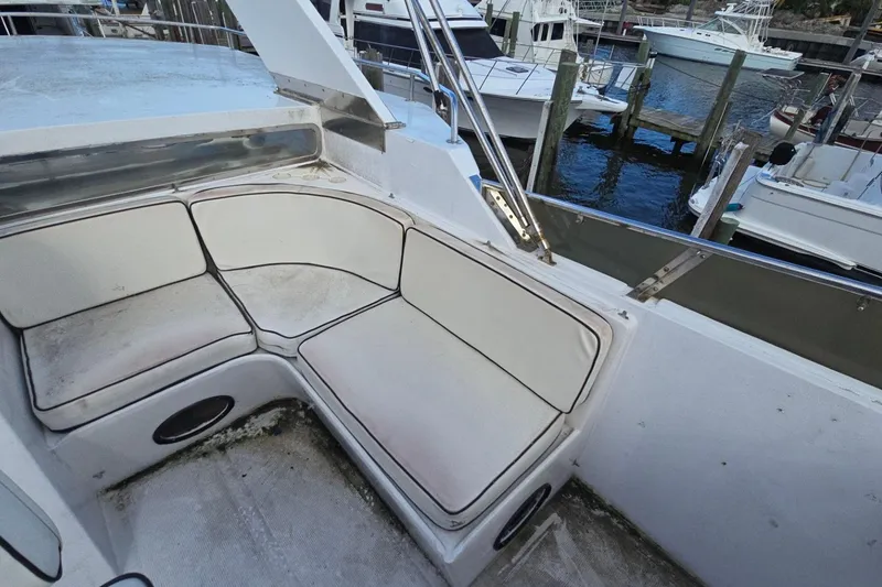 Slide: The Image of Cozy seating area on a 1990 Pace 42 boat, docked at a marina. - 11