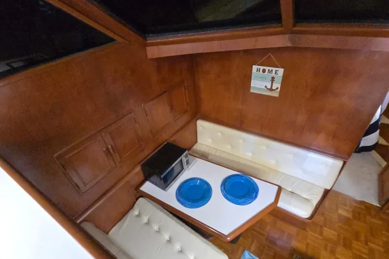Slide: The Image of Cozy dining area in a 1990 Pace 42 boat with wood paneling and blue plates. - 36