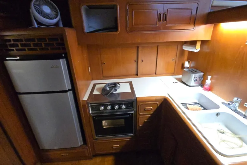 Slide: The Image of Compact kitchen in a 1990 Pace 42 boat with stove, fridge, and sink. - 30