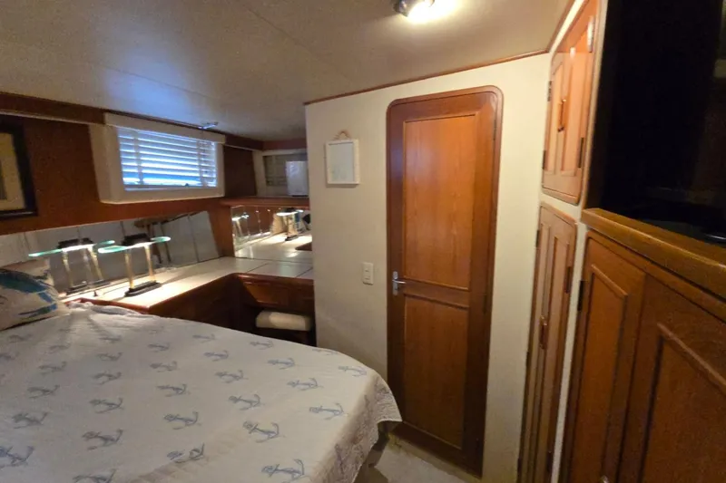 Slide: The Image of Cozy bedroom interior in 1990 Pace 42 yacht with wooden cabinetry and nautical-themed bedding. - 53