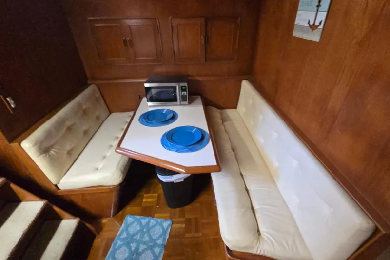 Slide: The Image of Cozy dining area in a 1990 Pace 42 boat with cushioned seating and a microwave. - 37