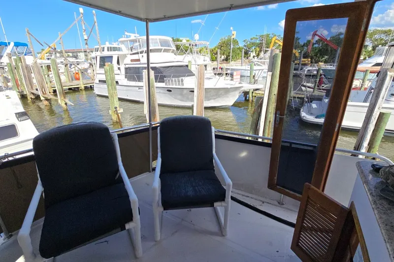 Slide: The Image of 1990 Pace 42 yacht deck with chairs, overlooking marina with docked boats. - 3