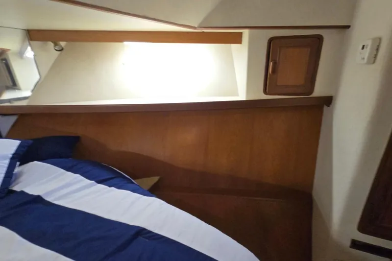 Slide: The Image of Cozy cabin interior of a 1990 Pace 42 boat with striped bedding and wooden accents. - 48
