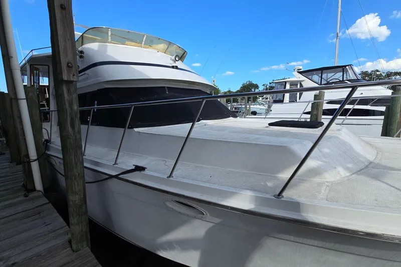 The Image of 1990 Pace 42 yacht docked at marina under clear blue sky. - 0