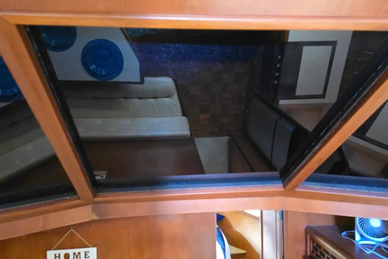 Slide: The Image of Interior view of a 1990 Pace 42 yacht, featuring wood paneling and seating area. - 43
