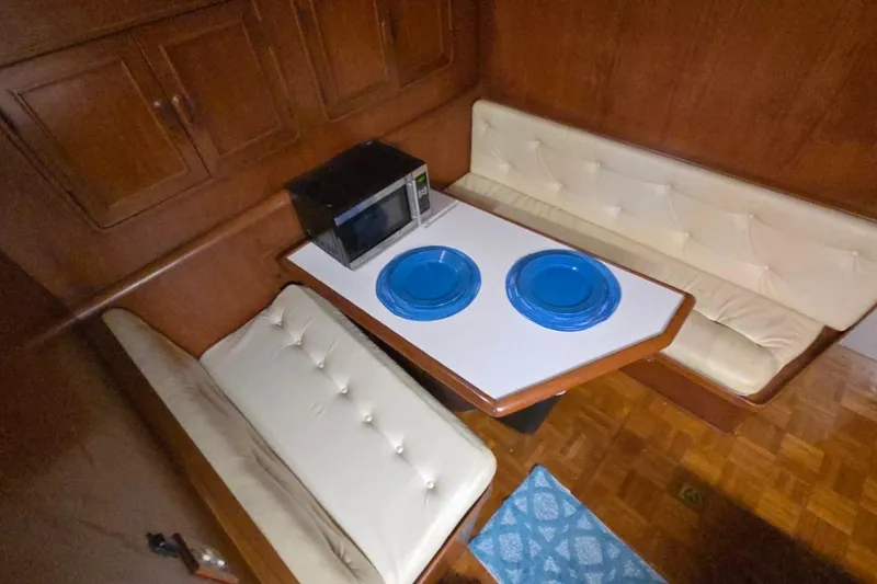 Slide: The Image of Cozy dining area in a 1990 Pace 42 boat with blue plates and a microwave. - 27