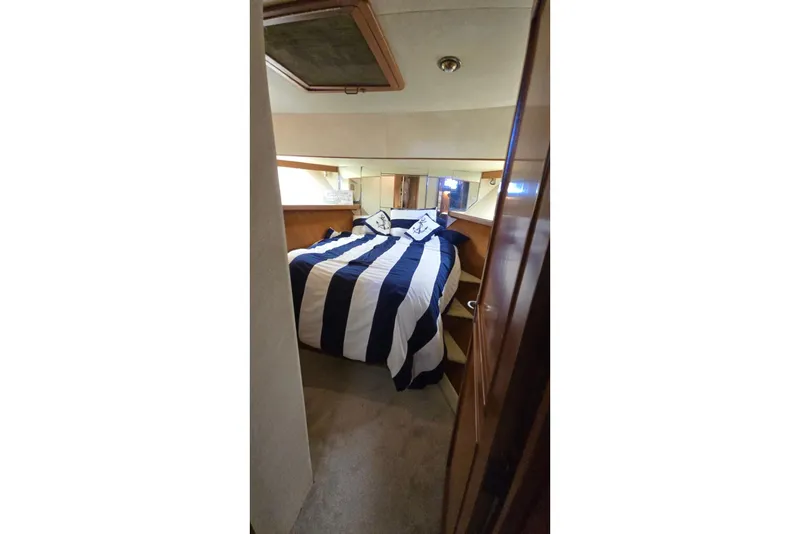 Slide: The Image of Cozy bedroom in 1990 Pace 42 yacht with striped bedding and wooden accents. - 45