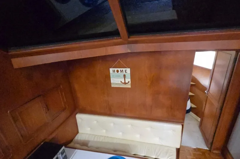 Slide: The Image of Interior of 1990 Pace 42 boat with wooden paneling and cozy seating area. - 29