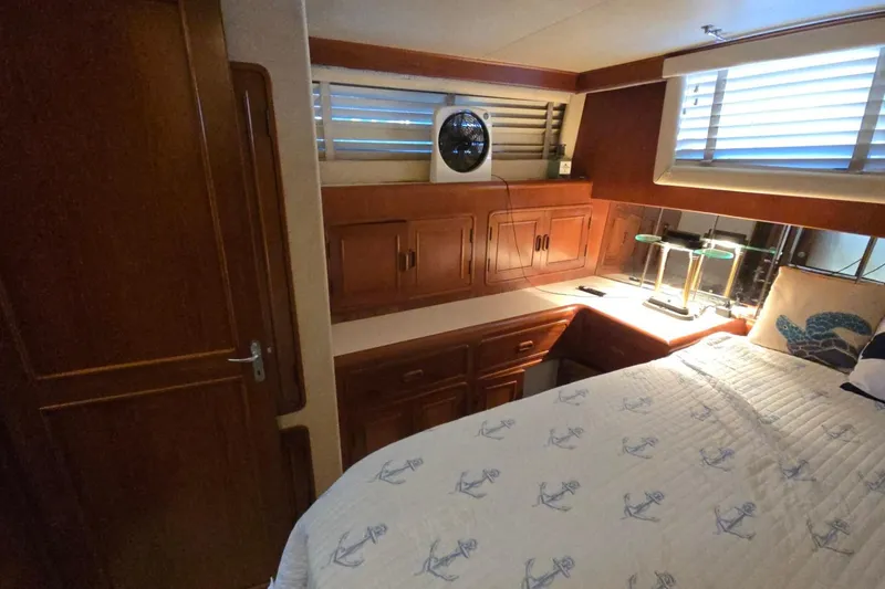 Slide: The Image of Cozy 1990 Pace 42 yacht cabin with wooden cabinets, bed, and nautical-themed decor. - 55