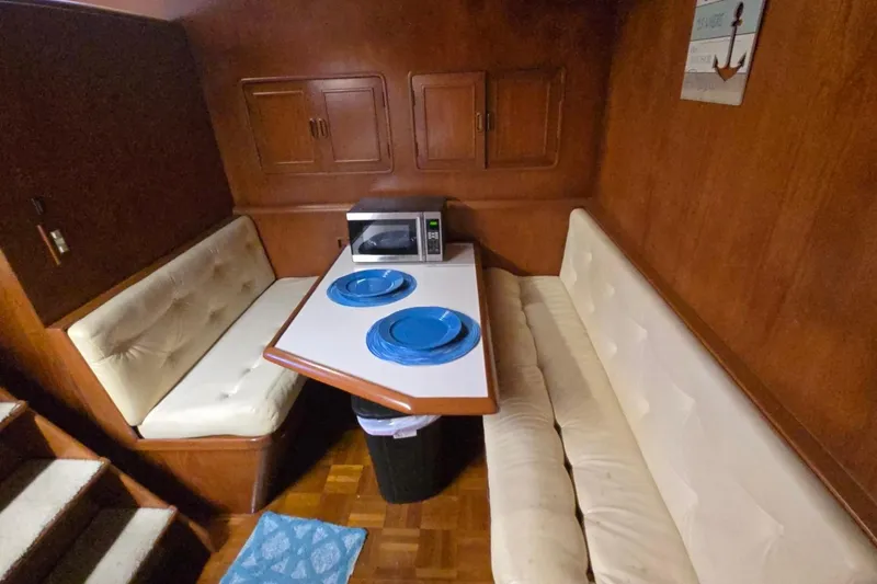 Slide: The Image of Cozy dining area in a 1990 Pace 42 boat with cushioned seating and a microwave. - 32