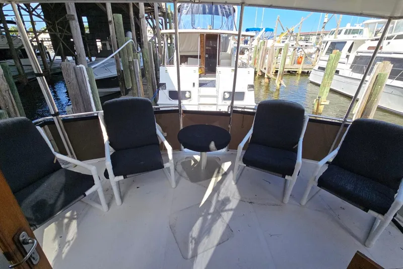 Slide: The Image of Deck seating area on 1990 Pace 42 yacht, featuring four chairs and a small table. - 2