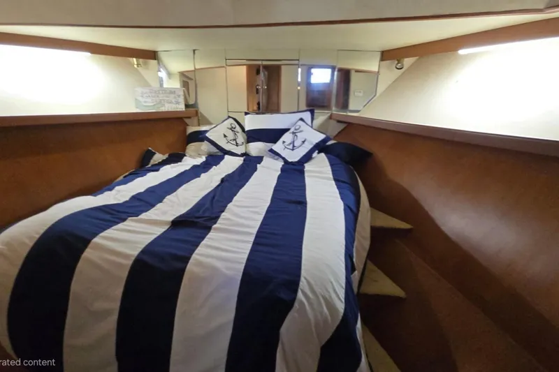 Slide: The Image of Cozy cabin interior of 1990 Pace 42 yacht with nautical-themed bedding. - 46