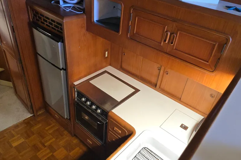 Slide: The Image of 1990 Pace 42 kitchen interior with wood cabinetry, stove, and refrigerator. - 41