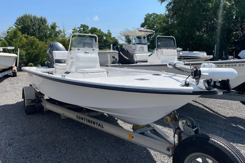 Slide: The Image of 2006 Kenner 180 VX boat on trailer, parked outdoors with other boats. - 1