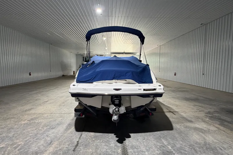 Slide: The Image of 2013 Chaparral 224 Sunesta boat in storage, covered with a blue tarp. - 3
