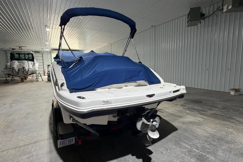 Slide: The Image of 2013 Chaparral 224 Sunesta boat with blue cover in a storage facility. - 5