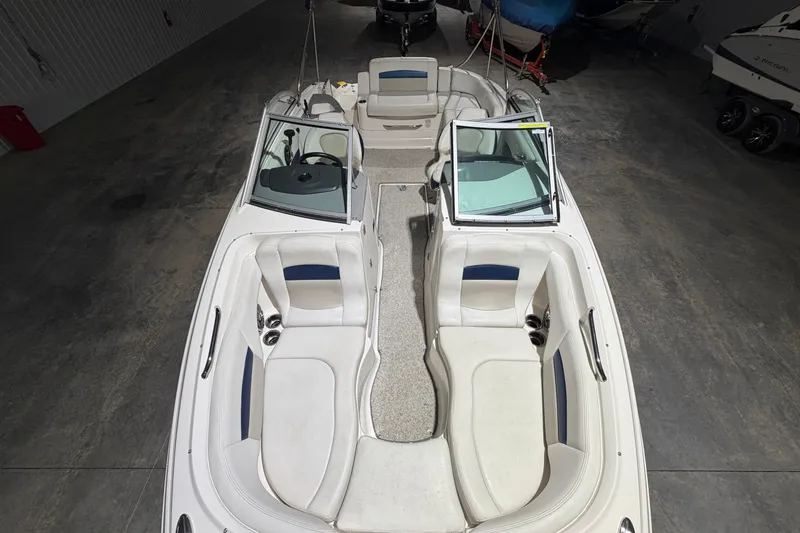 Slide: The Image of 2013 Chaparral 224 Sunesta boat interior with white seating, in a storage facility. - 13