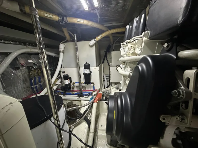 Slide: The Image of Engine room of a 2005 Carver 56 Voyager yacht, showcasing mechanical components and piping. - 47