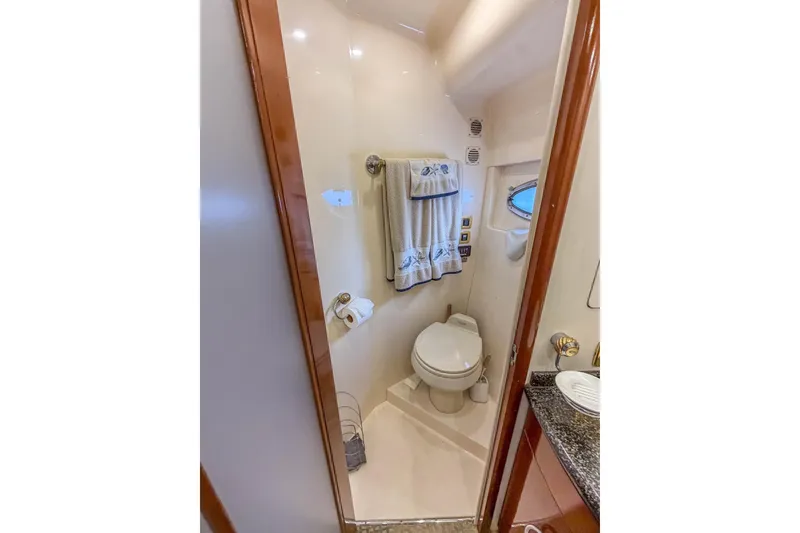 Slide: The Image of Bathroom interior of 2005 Carver 56 Voyager yacht, featuring toilet and towel rack. - 23