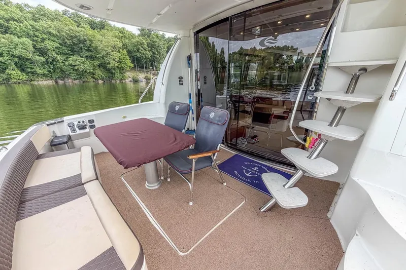 Slide: The Image of 2005 Carver 56 Voyager yacht deck with seating, table, and scenic lake view. - 36