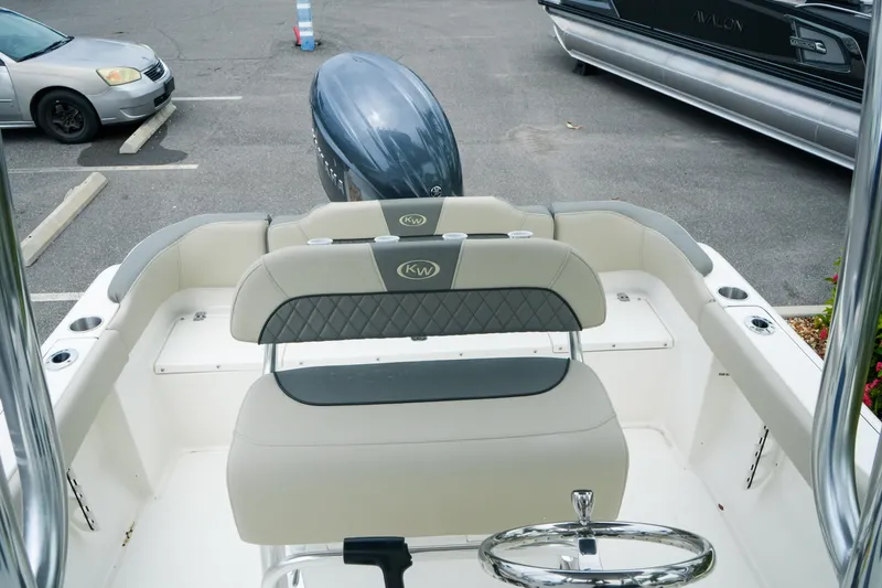 Slide: The Image of 2026 Key West 203 FS boat interior with seating and steering wheel in a parking lot. - 20