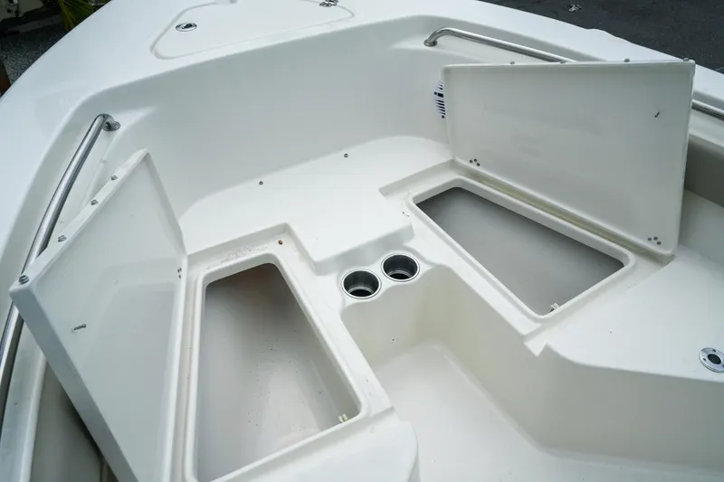 Slide: The Image of 2026 Key West 203 FS boat interior with open storage compartments and cup holders. - 16