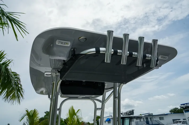 Slide: The Image of T-top of 2026 Key West 203 FS boat with rod holders under a cloudy sky. - 8