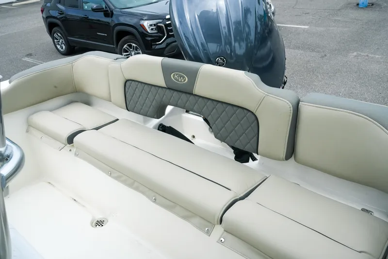 Slide: The Image of 2026 Key West 203 FS boat interior with cushioned seating and motor in parking lot. - 26