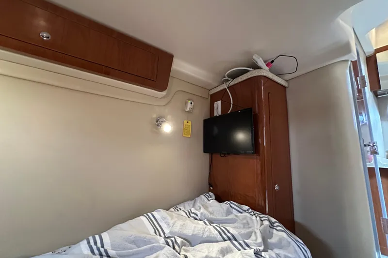 Slide: The Image of Interior cabin of 2008 Regal Commodore 4060 with bed, TV, and wooden cabinetry. - 26