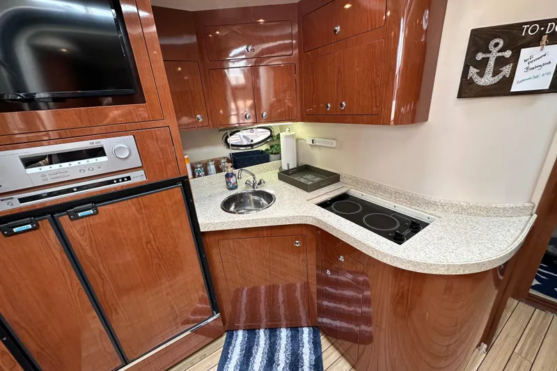 Slide: The Image of Luxurious 2008 Regal Commodore 4060 yacht kitchen with wood cabinetry and modern appliances. - 17