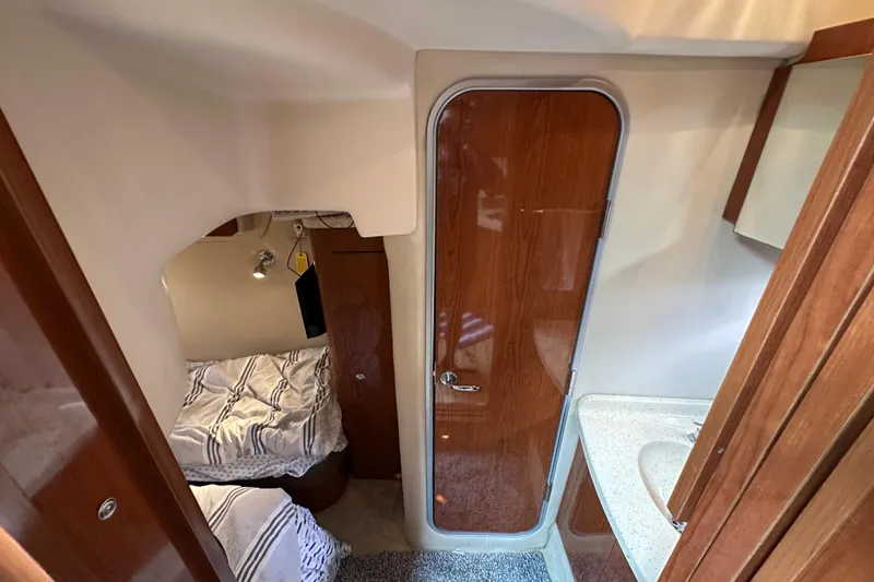 Slide: The Image of 2008 Regal Commodore 4060 cabin interior with wood finish and cozy sleeping area. - 24