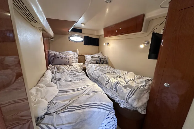 Slide: The Image of Cozy cabin interior of 2008 Regal Commodore 4060 with twin beds and striped bedding. - 25