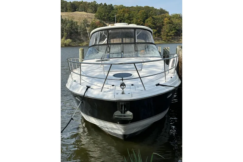 Slide: The Image of 2008 Regal Commodore 4060 boat docked on a calm lake with scenic background. - 2