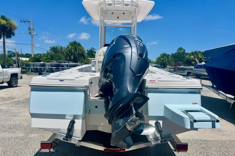 Slide: The Image of 2026 Robalo 246 Cayman boat with powerful outboard motor, parked outdoors under clear blue sky. - 4
