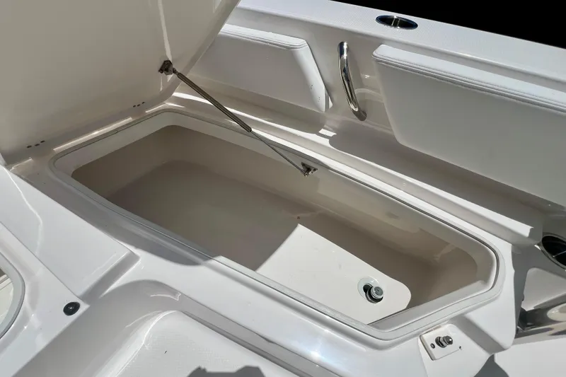 Slide: The Image of Open storage compartment on 2026 Robalo 246 Cayman boat, showcasing spacious interior design. - 26