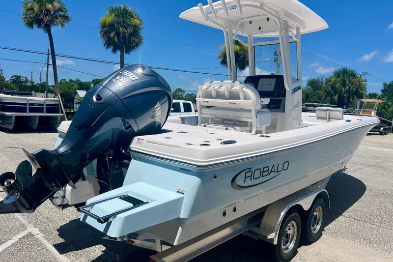 Slide: The Image of 2026 Robalo 246 Cayman boat with powerful outboard motor, parked on a trailer. - 5