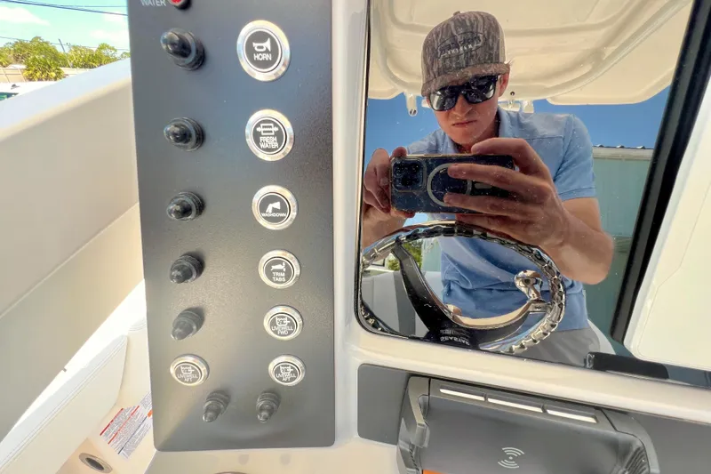 Slide: The Image of Reflection on 2026 Robalo 246 Cayman boat dashboard with control panel and steering wheel. - 17