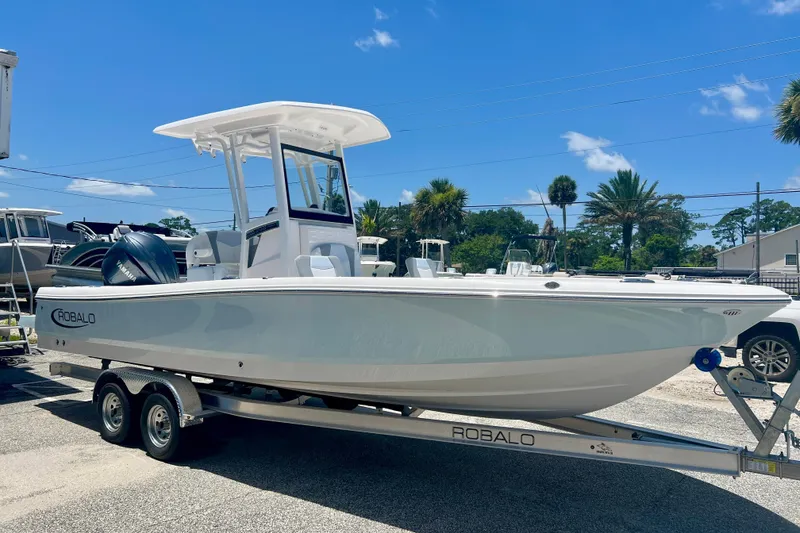 Slide: The Image of 2026 Robalo 246 Cayman boat on trailer under clear blue sky. - 6