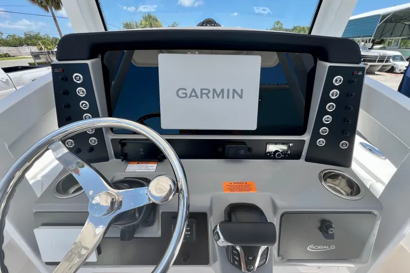 Slide: The Image of 2026 Robalo 246 Cayman boat dashboard with Garmin navigation system and steering wheel. - 15