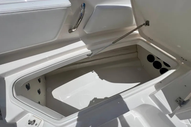 Slide: The Image of Open storage compartment on 2026 Robalo 246 Cayman boat, showcasing spacious interior design. - 25