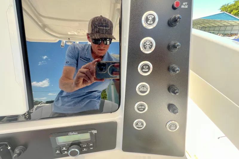 Slide: The Image of Reflection on Robalo 246 Cayman 2026 dashboard with control panel and Clarion stereo. - 16