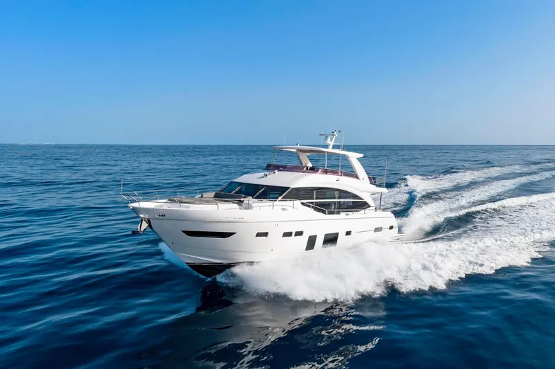 The Image of Luxurious 2018 Princess Y75 yacht cruising on open sea under clear blue sky. - 1
