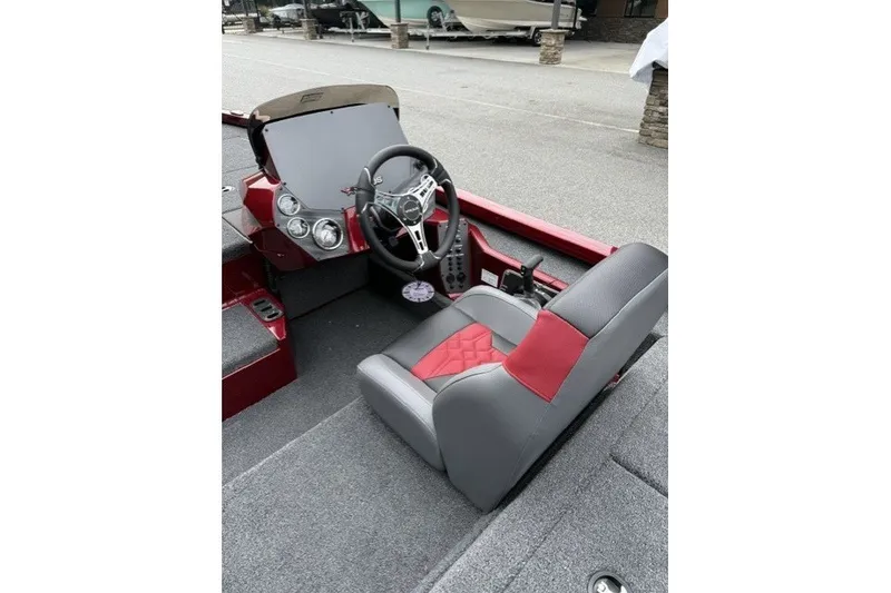 Slide: The Image of Interior of a 2027 Vexus AVX1880 boat featuring a sleek steering console and red-accented seat. - 6
