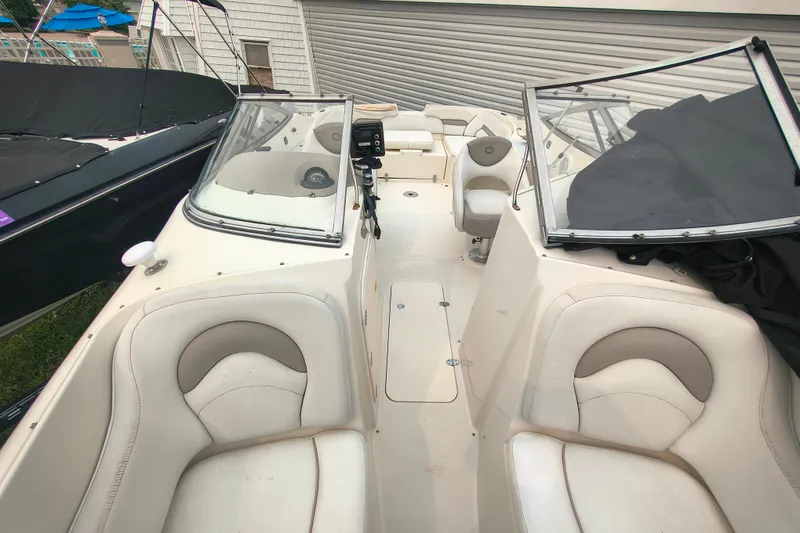 Slide: The Image of 2006 Stingray 250 LR boat interior with beige seating and dual windshields. - 11
