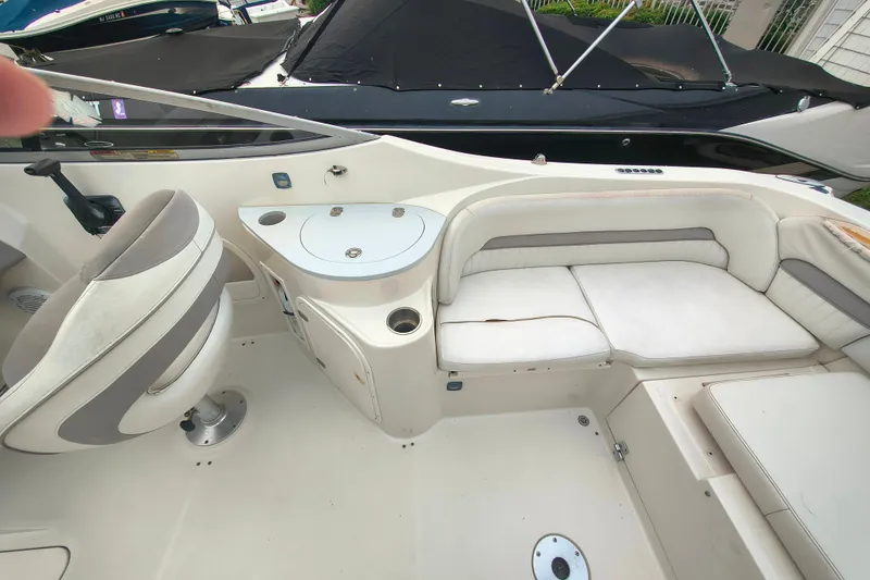 Slide: The Image of 2006 Stingray 250 LR boat interior with seating and helm, featuring white and gray upholstery. - 5