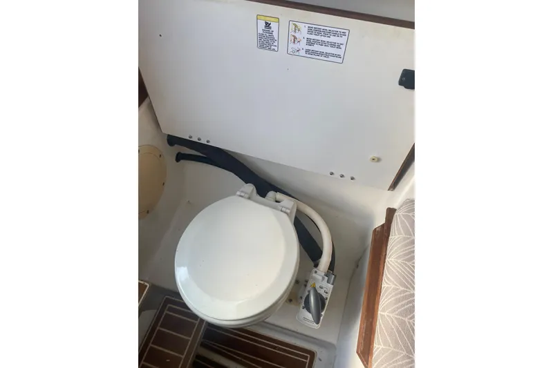 Slide: The Image of 1994 Robalo 2440 Walkaround boat toilet interior with manual flush system. - 15
